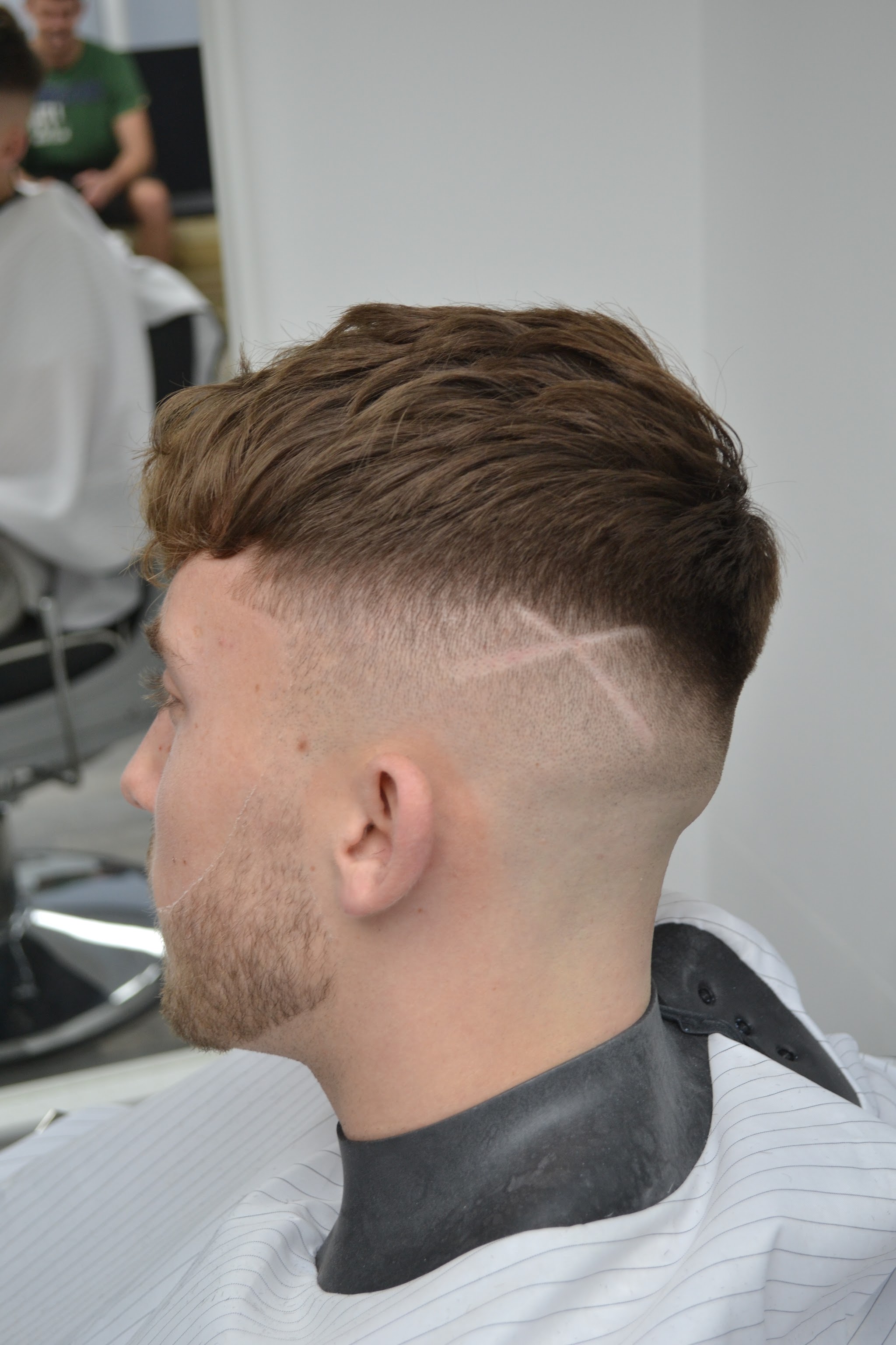 Skin fade with a shaved part line and textured top