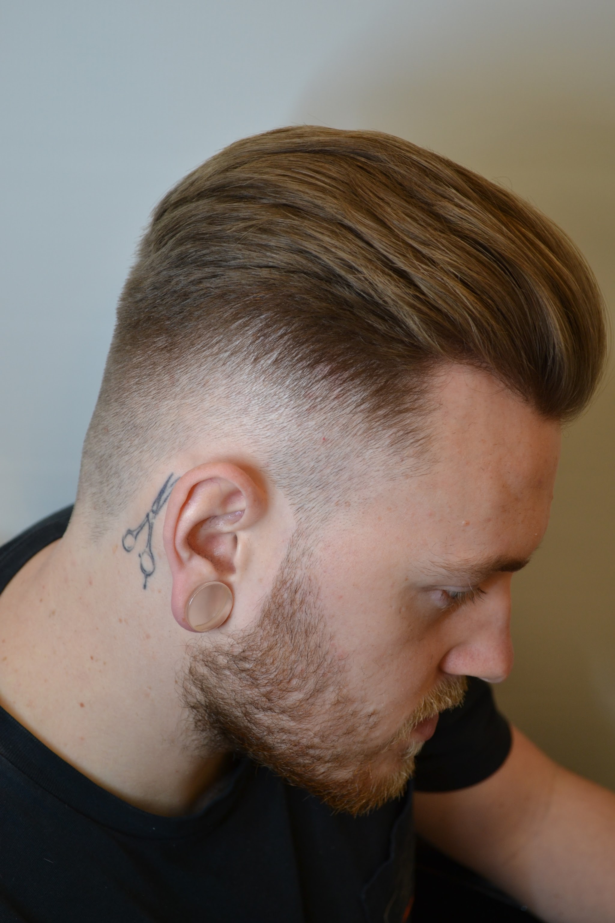 Slicked back cut with a skin fade and beard