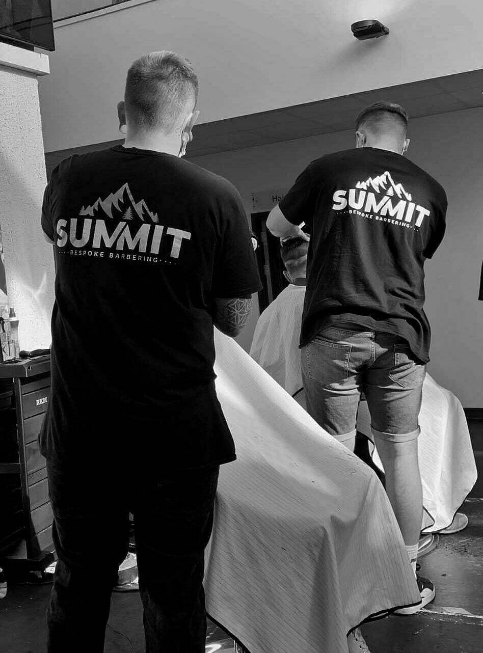 Two barbers in Summit T-shirts at work