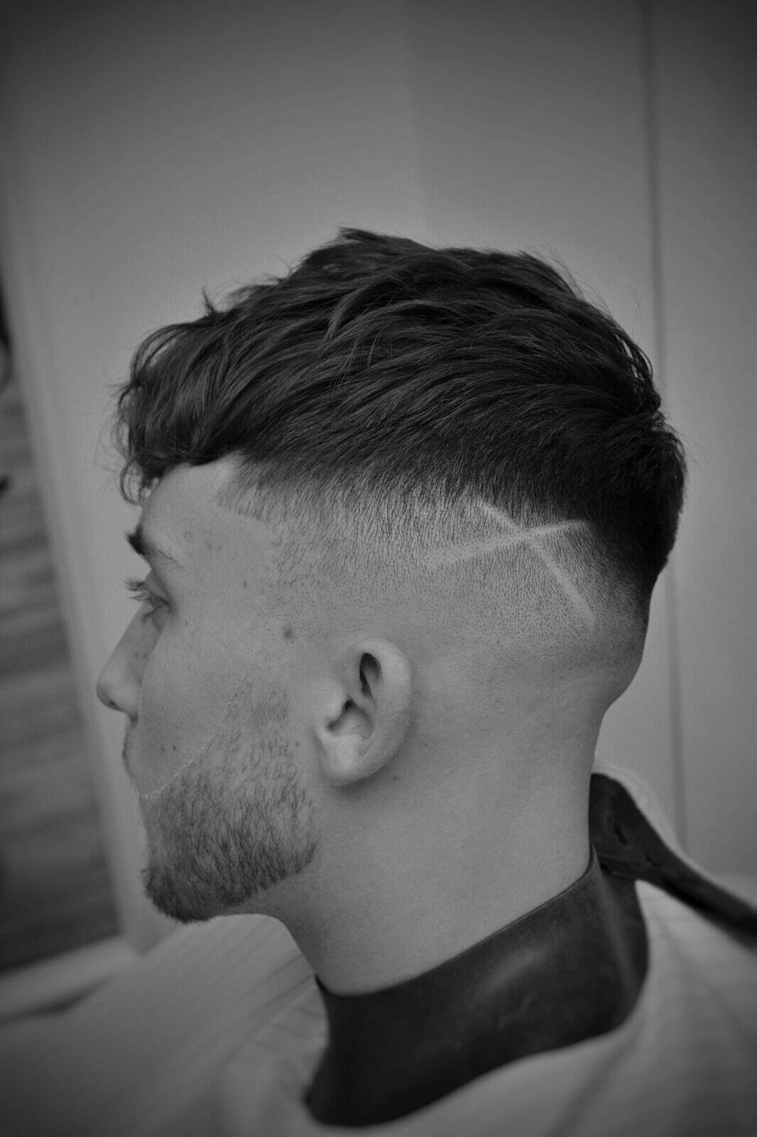 Skin fade with a hard part, in black and white